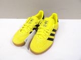 yellow adidas sneakers with black and white stripes are on a white surface