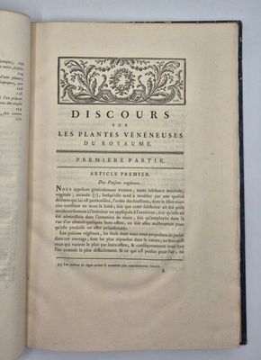 un livre ouvert posé sur une table blanche bordée de noir