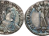a silver coin with an image of a man holding a sword