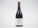 une bouteille de vin rouge posée sur une table blanche