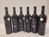 six bottles of wine are lined up in a row on a table
