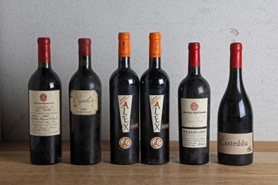 several bottles of wine are lined up on a wooden table
