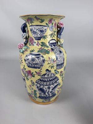 un vase jaune orné de motifs bleus et blancs