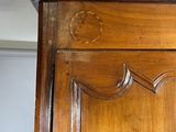 a wooden armoire with a clock on top of it