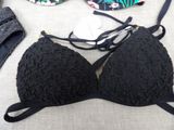 a black bra top and a pair of shoes on a bed