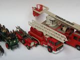un camion de pompiers miniature et d'autres véhicules miniatures posés sur une surface blanche