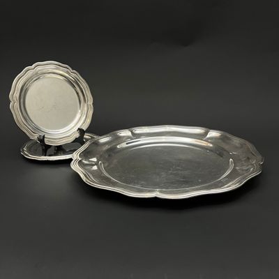 paire de plats argentés sur des socles, sur fond noir