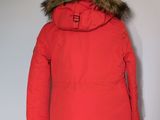 the back of a red jacket with a fur collar on a mannequin stand