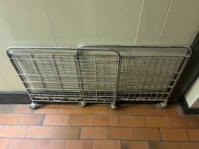 Un chariot à pain en inox pliant sur roulette. En l'état