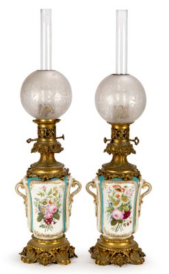 pair of antique lamps with floral designs on them on a white background