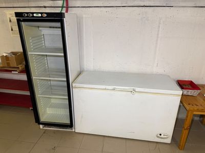 un réfrigérateur vide et une petite table dans une pièce