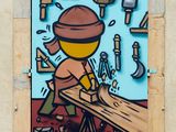 painting of a man working on a piece of wood on a wall