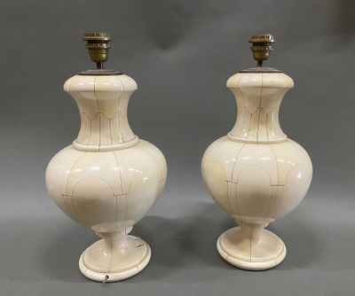 pair of white vases sitting on top of each other on a gray surface