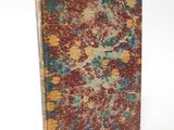 an old book with red and blue paint on it