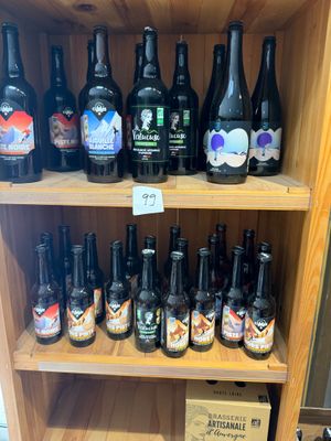 Des bouteilles de bière sont posées sur une étagère en bois dans un magasin.