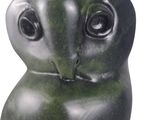 a green owl statue sitting on a white surface