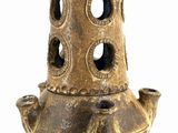 a brown vase with holes in it on a white background