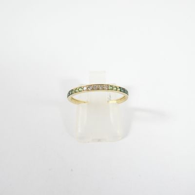 a close up of a gold ring with green and white diamonds