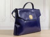 a blue handbag sitting on top of a wooden table