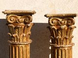two gold colored columns sitting next to each other on a wall
