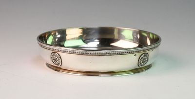 a silver bowl with a design on it on a white surface
