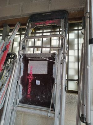 several skis and ski poles are lined up against a wall
