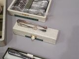 a box of silverware and a knife on a table