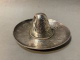 a silver hat sitting on top of a silver plate
