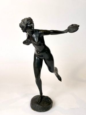 statue of a woman holding a tennis racquet in her right hand