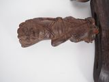 a wooden carving of a hand holding a knife