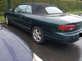 une voiture verte garée sur un parking à côté d'autres voitures