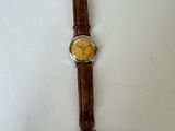 an image of a watch on a white surface with a brown strap