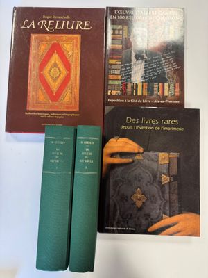 trois livres posés sur une table, les uns à côté des autres, sur une surface blanche