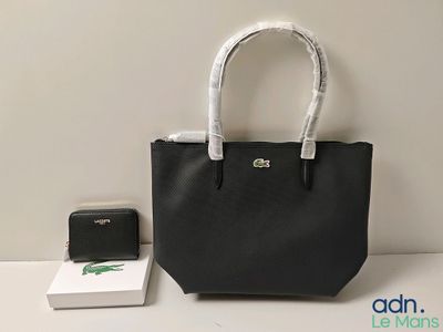 un sac à main noir et blanc et un portefeuille posés sur une table