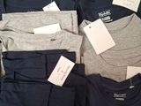 a lot of t - shirts that are sitting on a table