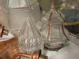 three glass bottles on a table next to a brass faucet
