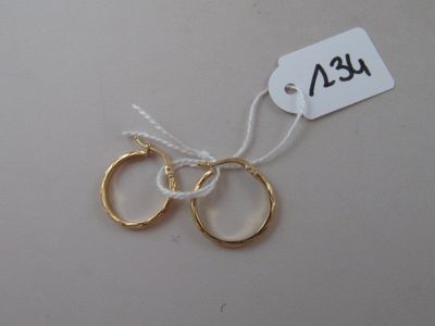 two gold rings on a string with a price tag