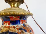 a lamp that is on a table with a white wall in the background