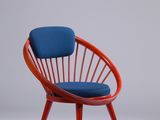 une chaise rouge avec un coussin bleu dessus