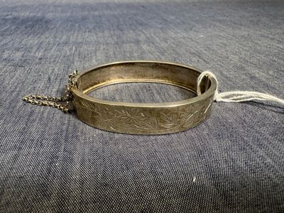 un gros plan sur un bracelet en or entouré d'une chaîne
