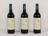 trois bouteilles de vin sont alignées sur une table