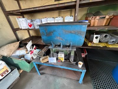 une machine bleue posée dans un garage à côté d'autres objets