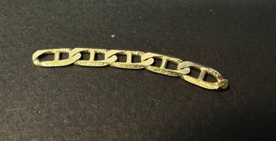 a close up of a gold chain on a black surface