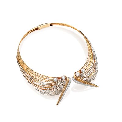 un gros plan d'un collier en or et diamants sur fond blanc