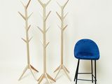 une chaise bleue et un porte-manteau en bois sur fond blanc