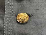 four gold buttons on a black jacket with a white background