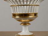 a white and gold vase sitting on a wooden table