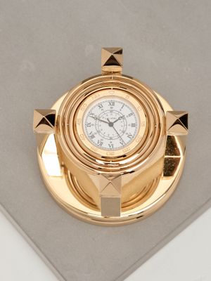 une horloge en or posée sur un plateau en or