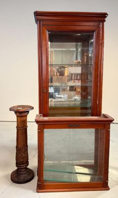 une vitrine en verre avec un bougeoir à côté