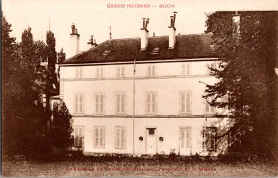 une vieille photo d'un grand bâtiment blanc avec une horloge sur la façade